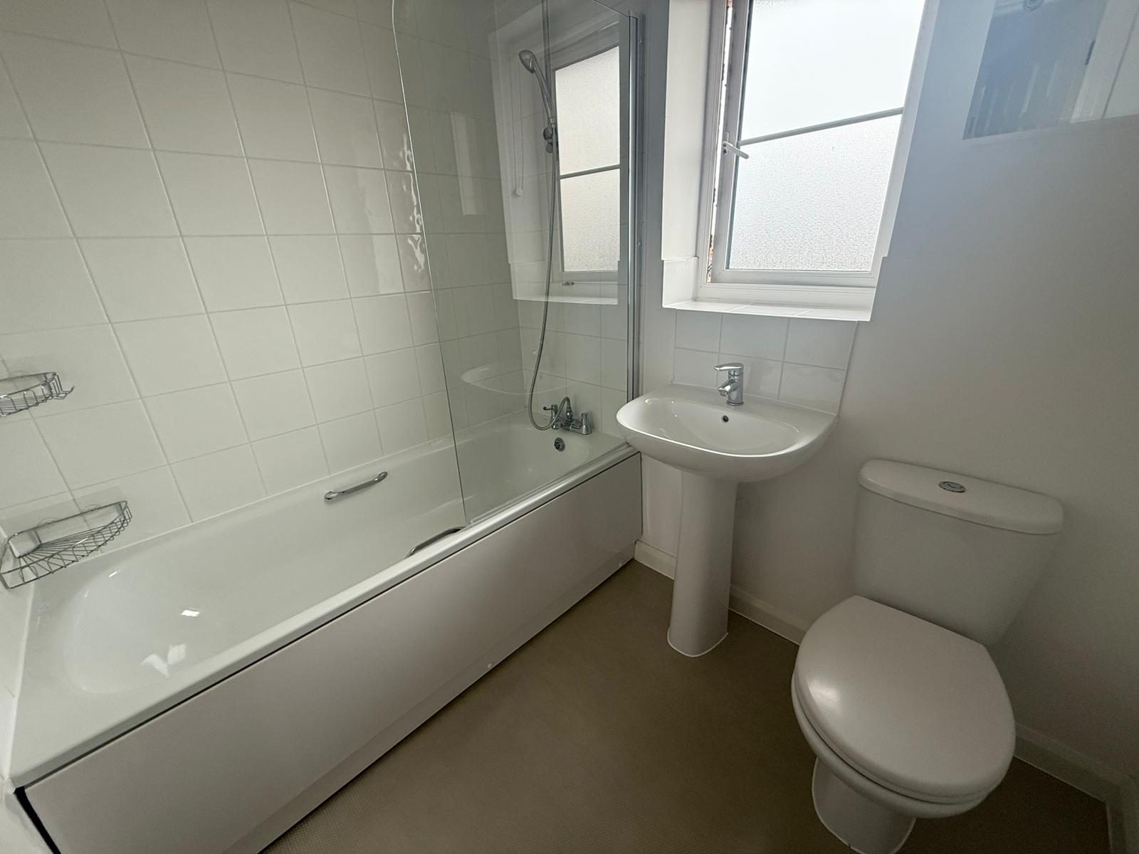Bathroom with bath, shower over and glass screen