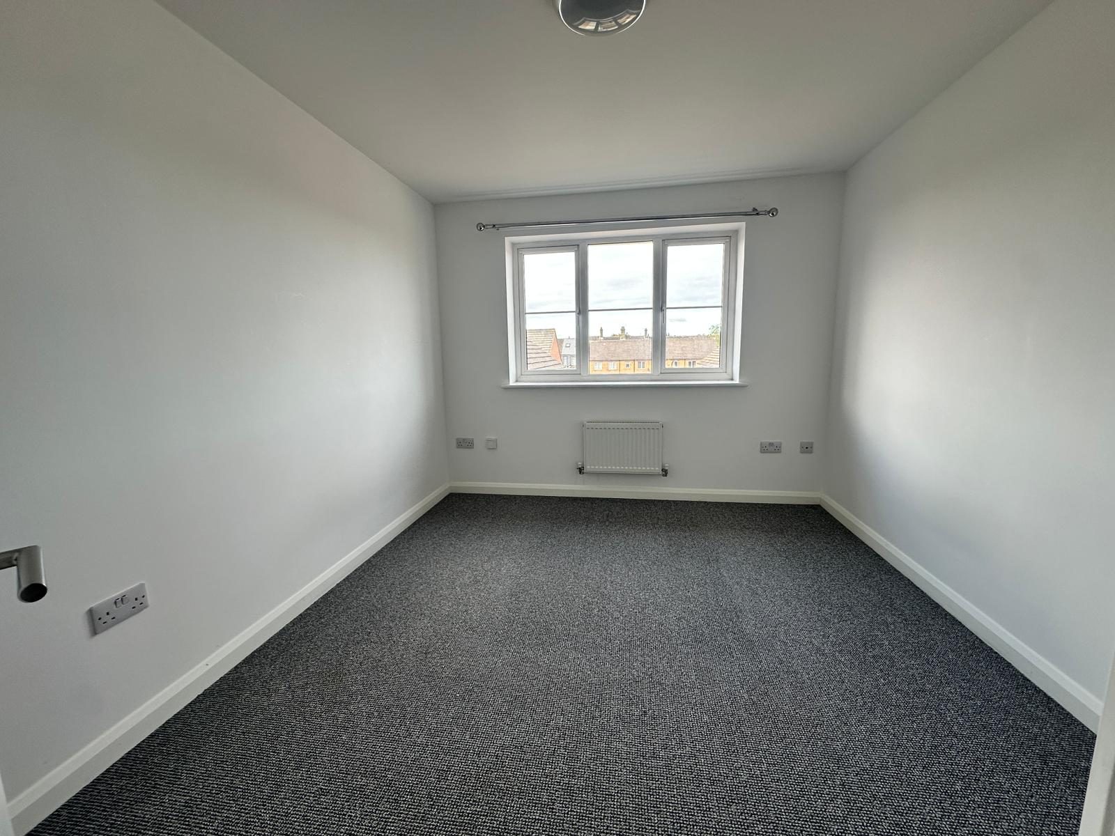 Double bedroom with new carpet and a large window