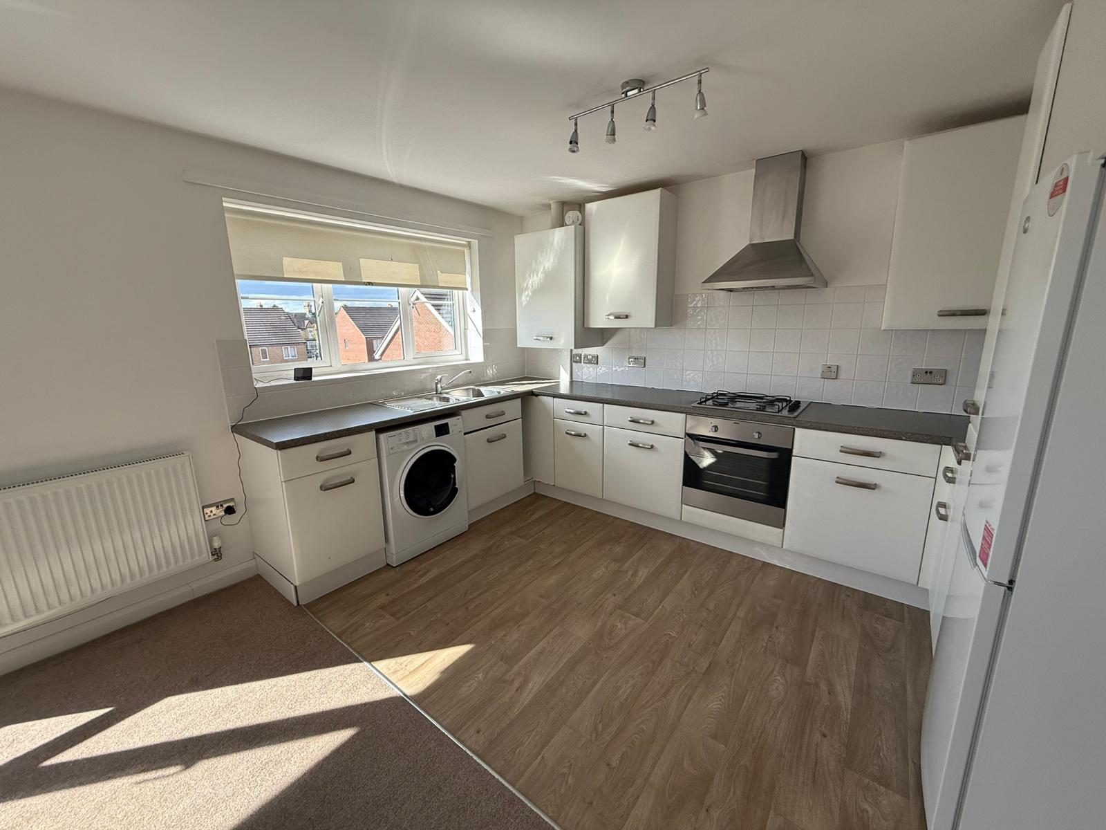 Fitted kitchen with gas hob, oven, extractor hood and washer dryer