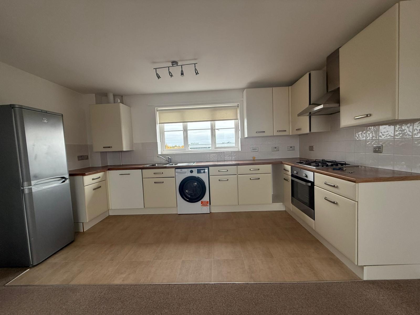 Fitted kitchen with gas hob, oven, washing machine and fridge freezer